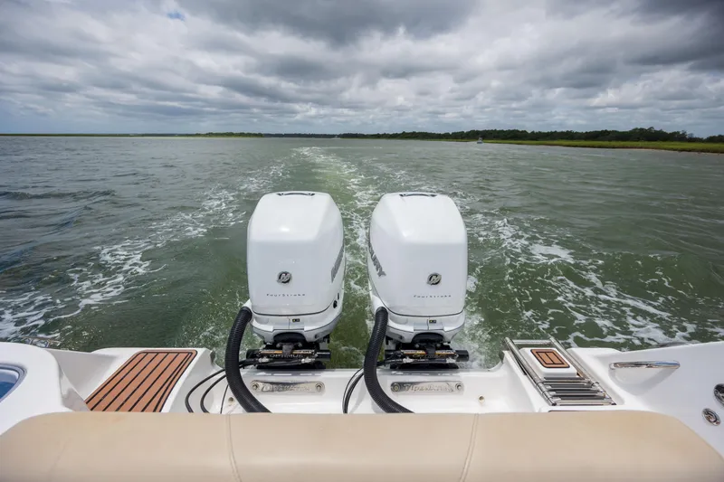 Slide: The Image of 2020 Tidewater 320 CC Adventure boat with dual outboard motors on open water. - 12