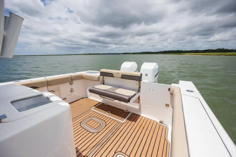 Slide: The Image of 2020 Tidewater 320 CC Adventure boat with spacious deck and dual engines on open water. - 13