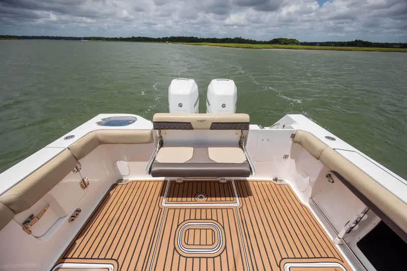 Slide: The Image of 2020 Tidewater 320 CC Adventure boat interior with cushioned seating and dual engines. - 14