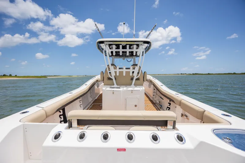 Slide: The Image of 2020 Tidewater 320 CC Adventure boat on calm water under blue sky. - 15