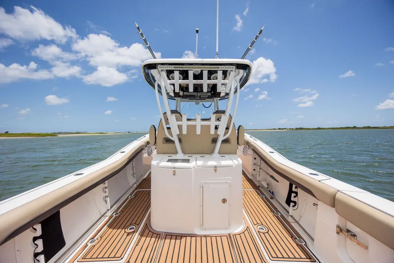 Slide: The Image of 2020 Tidewater 320 CC Adventure boat on water, featuring spacious deck and clear sky. - 16