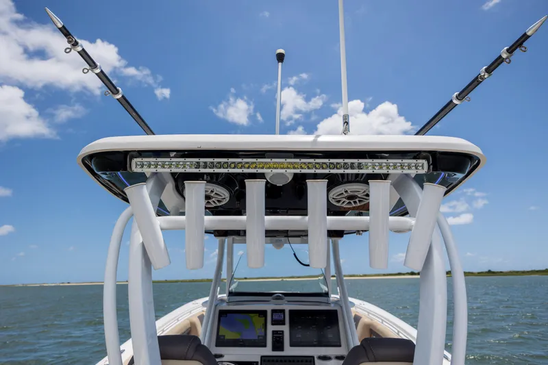 Slide: The Image of 2020 Tidewater 320 CC Adventure boat with fishing rods and electronics, under a clear blue sky. - 17