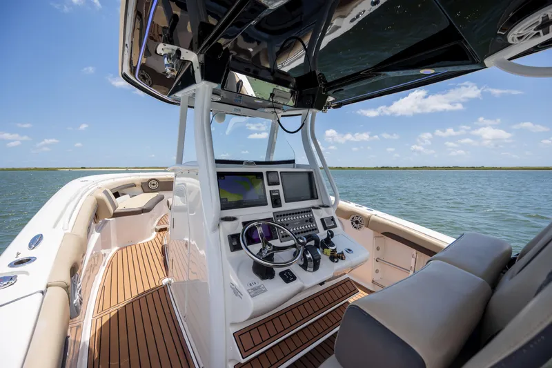 Slide: The Image of 2020 Tidewater 320 CC Adventure boat interior with navigation system on open water. - 18