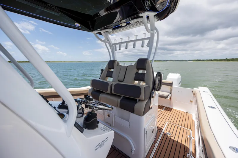Slide: The Image of 2020 Tidewater 320 CC Adventure boat interior with helm and seating on open water. - 19