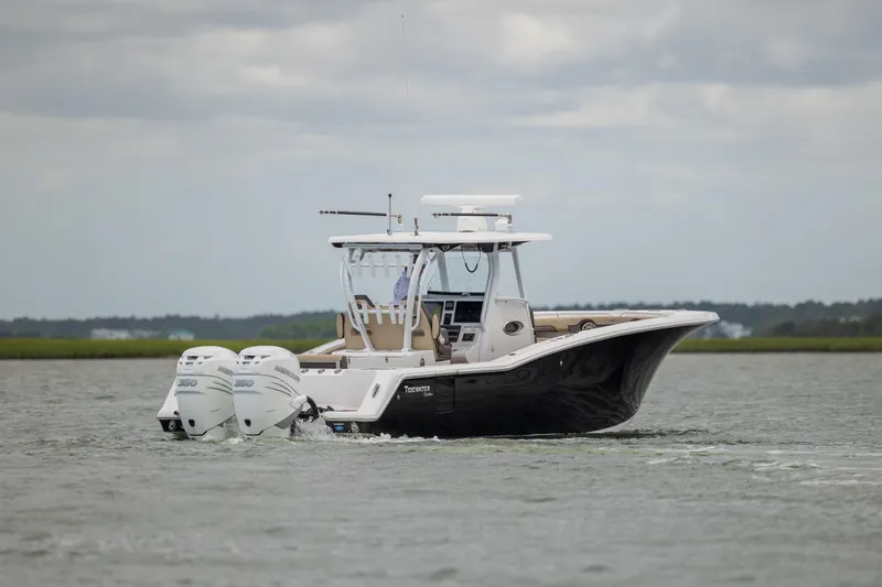 Slide: The Image of 2020 Tidewater 320 CC Adventure boat cruising on a calm waterway. - 2