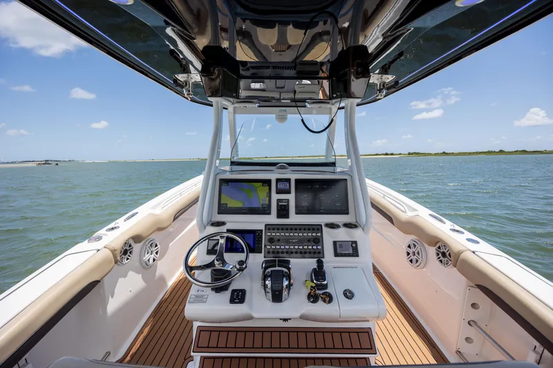 Slide: The Image of Cockpit view of 2020 Tidewater 320 CC Adventure boat on open water. - 20