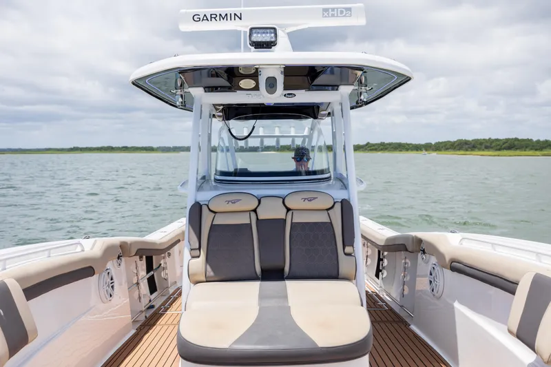 Slide: The Image of 2020 Tidewater 320 CC Adventure boat interior with seating, on a calm water body. - 25