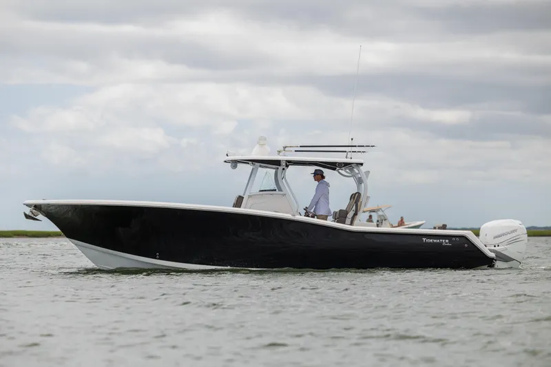Slide: The Image of 2020 Tidewater 320 CC Adventure boat cruising on calm waters under cloudy skies. - 3