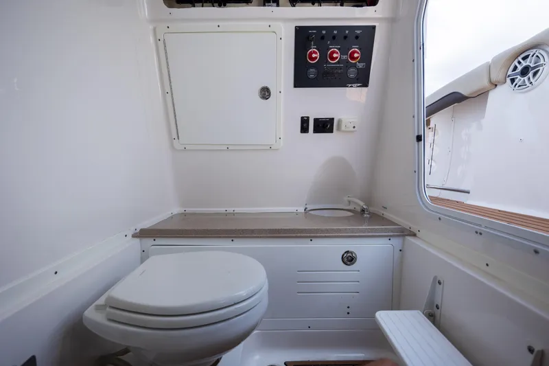Slide: The Image of 2020 Tidewater 320 CC Adventure boat interior with toilet and control panel. - 32