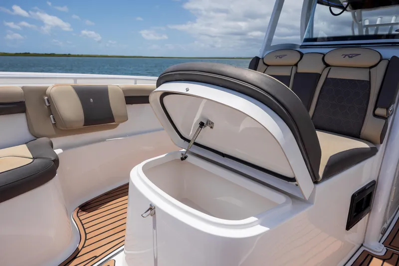 Slide: The Image of 2020 Tidewater 320 CC Adventure boat with open storage compartment and cushioned seating. - 36