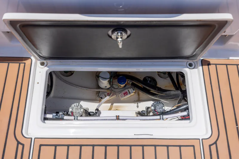 Slide: The Image of 2020 Tidewater 320 CC Adventure boat storage compartment with visible wiring and components. - 37