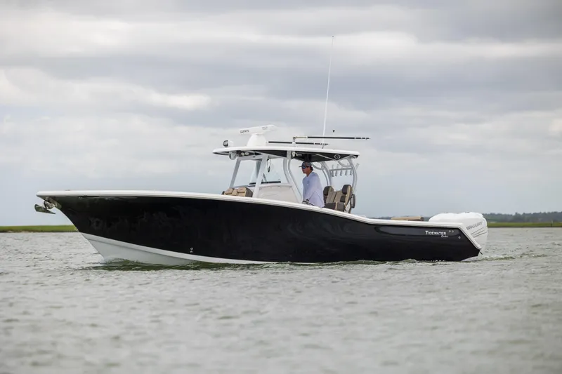 Slide: The Image of 2020 Tidewater 320 CC Adventure boat cruising on water under cloudy skies. - 4