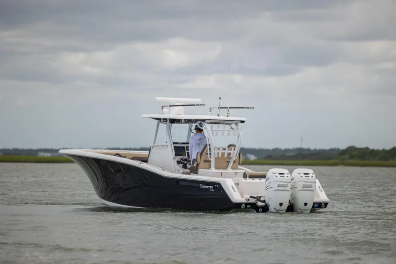Slide: The Image of 2020 Tidewater 320 CC Adventure boat cruising on a calm waterway. - 8