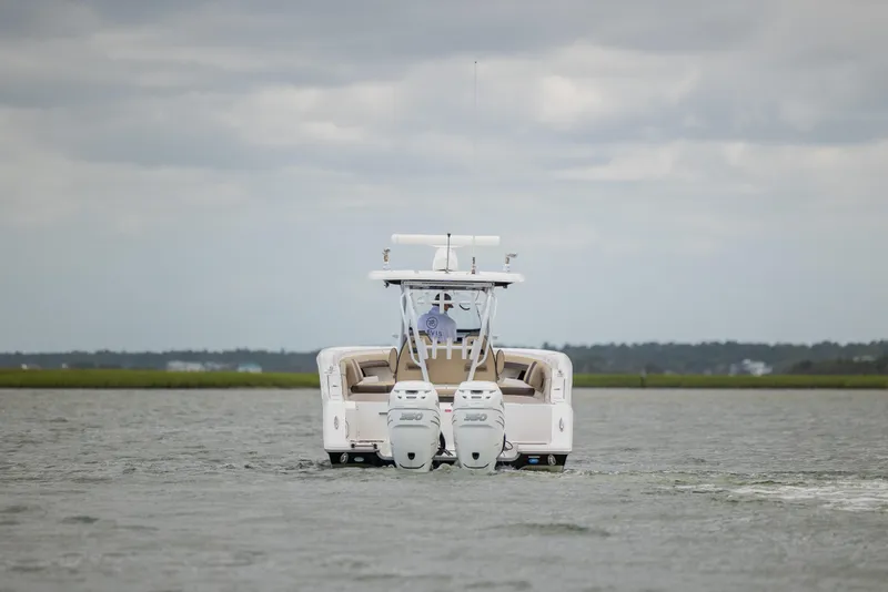 Slide: The Image of 2020 Tidewater 320 CC Adventure boat on water, rear view with dual engines. - 9
