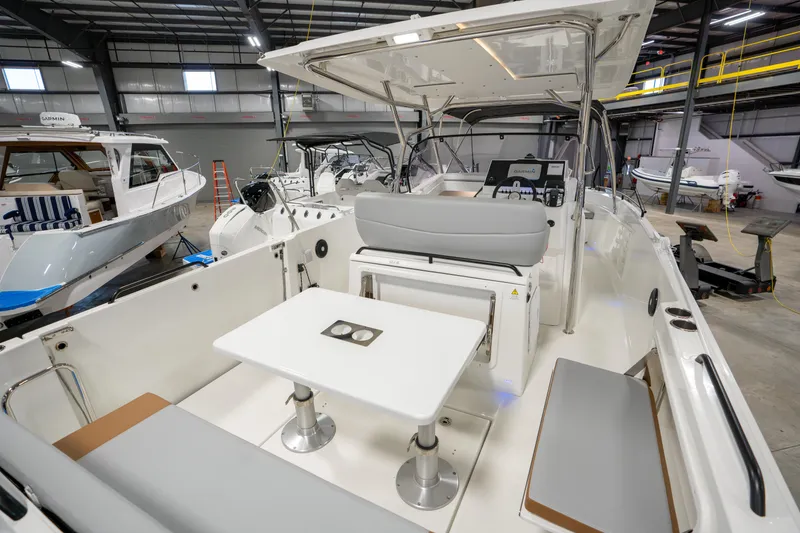 Slide: The Image of 2025 Beneteau Flyer 9 SPACEdeck interior with seating and table in a showroom. - 12