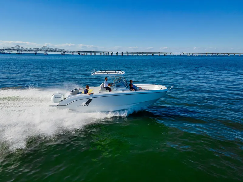 Slide: The Image of 2025 Beneteau Flyer 9 SPACEdeck cruising on open water near a bridge. - 3