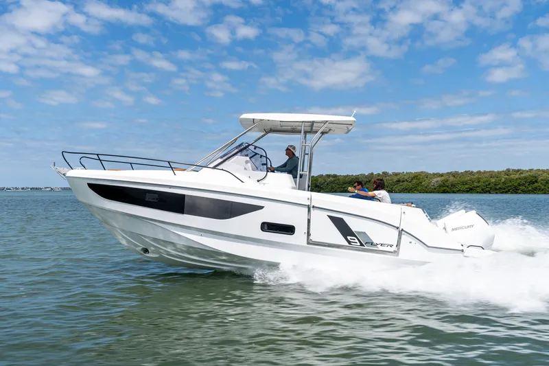 Slide: The Image of 2025 Beneteau Flyer 9 SUNdeck cruising on water under a clear blue sky. - 1