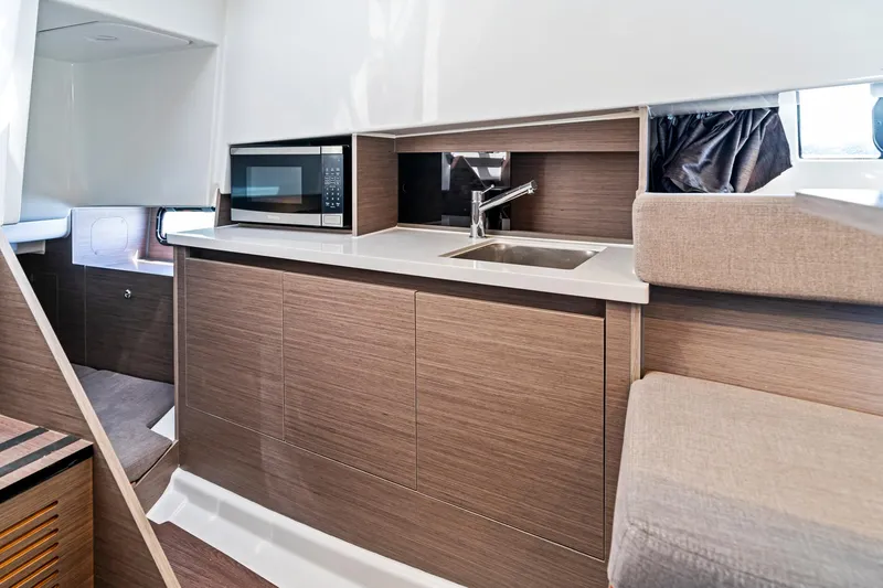 Slide: The Image of 2025 Beneteau Flyer 9 SUNdeck interior with kitchenette, featuring a sink and microwave. - 15