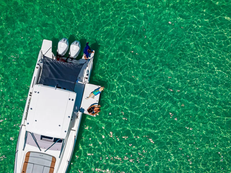 Slide: The Image of 2025 Beneteau Flyer 9 SUNdeck on clear turquoise water, aerial view. - 23