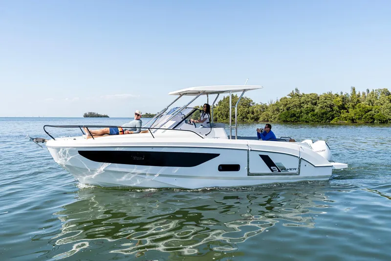Slide: The Image of 2025 Beneteau Flyer 9 SUNdeck boat cruising on calm waters near lush greenery. - 27