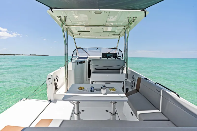 Slide: The Image of 2025 Beneteau Flyer 9 SUNdeck on turquoise water, featuring a spacious seating area and table. - 5