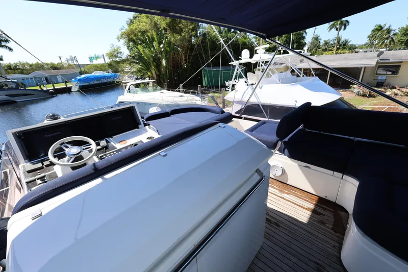 Slide: The Image of Flybridge view of 2016 Sunseeker Manhattan 55 yacht docked near lush greenery. - 30