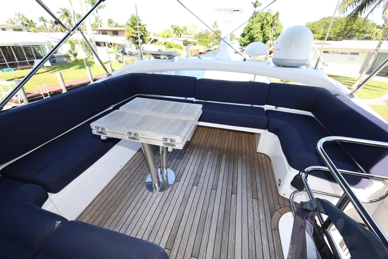 Slide: The Image of Luxurious 2016 Sunseeker Manhattan 55 yacht deck with seating and table, surrounded by greenery. - 32