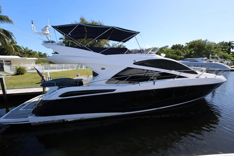 Slide: The Image of 2016 Sunseeker Manhattan 55 yacht docked in a serene marina setting. - 4