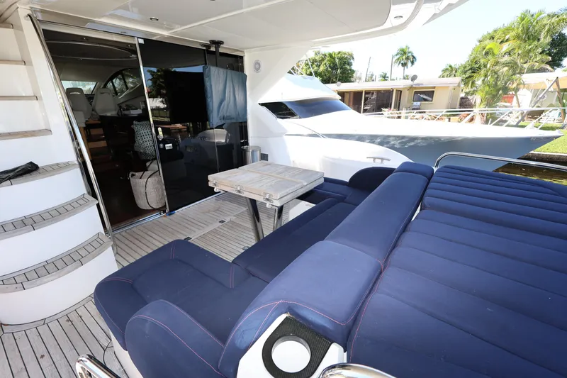 Slide: The Image of Luxurious 2016 Sunseeker Manhattan 55 yacht deck with seating and table, docked near palm trees. - 44