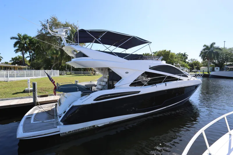 Slide: The Image of 2016 Sunseeker Manhattan 55 yacht docked by a lush, tropical waterfront. - 5
