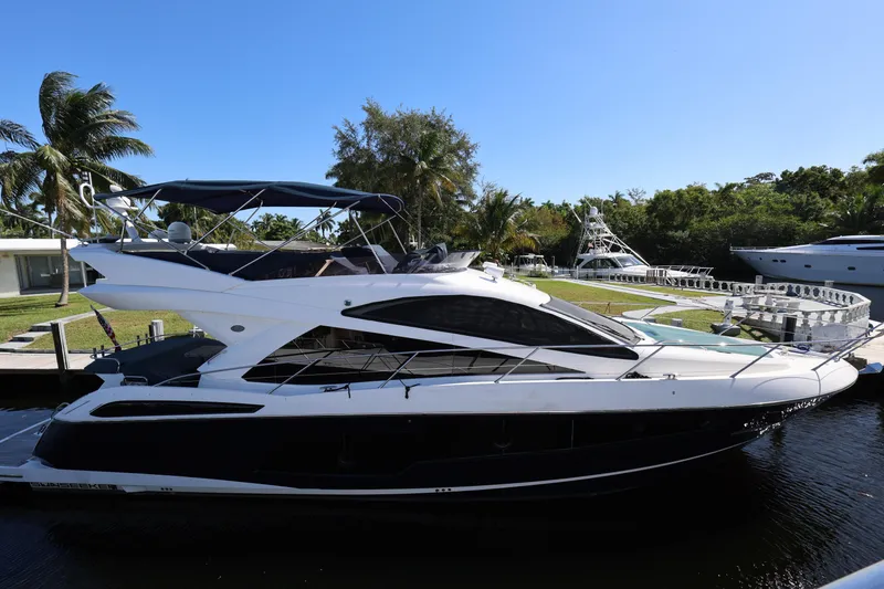 Slide: The Image of 2016 Sunseeker Manhattan 55 yacht docked by palm trees under clear blue sky. - 7
