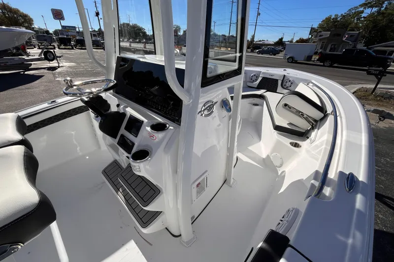 Slide: The Image of 2026 Tidewater 210 CC Adventure boat interior with steering console and seating. - 11