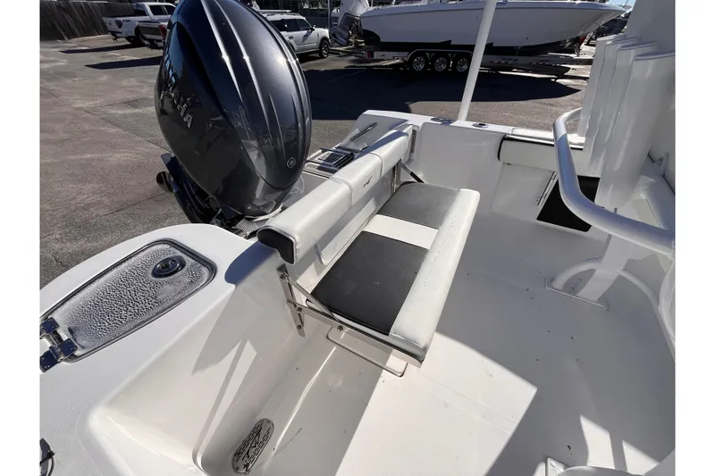 Slide: The Image of 2026 Tidewater 210 CC Adventure boat interior with seating and motor view. - 13