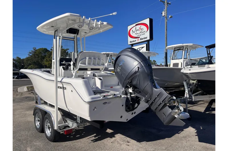 Slide: The Image of 2026 Tidewater 210 CC Adventure boat on trailer, displayed at Marker 17 Marine dealership. - 2
