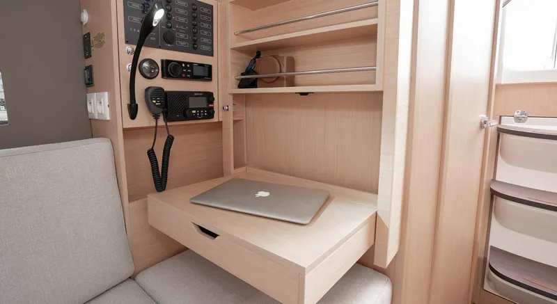 Slide: The Image of 2025 Beneteau Oceanis 30.1 yacht interior with navigation station and laptop. - 13
