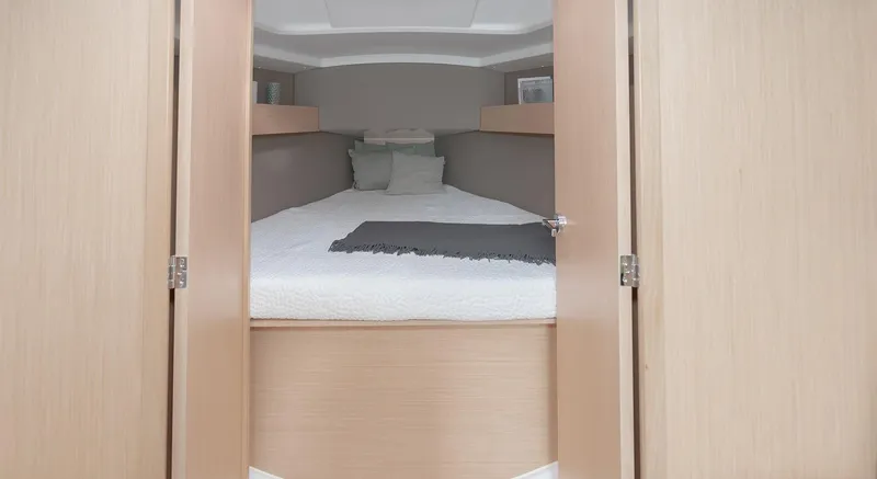 Slide: The Image of Interior cabin of 2025 Beneteau Oceanis 30.1 yacht, featuring a cozy bed and wooden finish. - 16