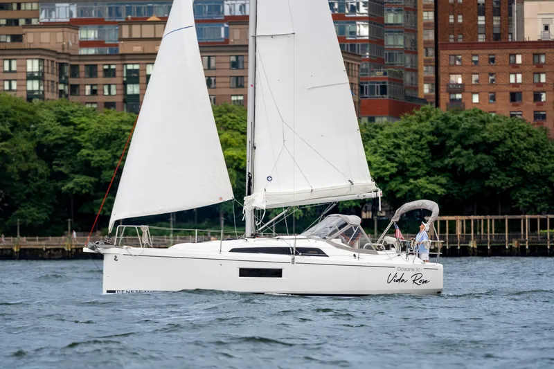 Slide: The Image of 2025 Beneteau Oceanis 30.1 sailboat on water, urban skyline background. - 2