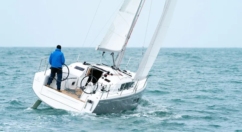 Slide: The Image of 2025 Beneteau Oceanis 30.1 sailing on open sea with person at helm. - 5