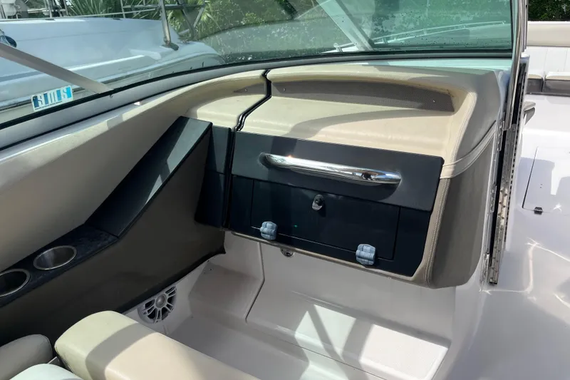 Slide: The Image of 2014 Regal 3200 Bowrider interior dashboard with cup holders and storage compartment. - 31