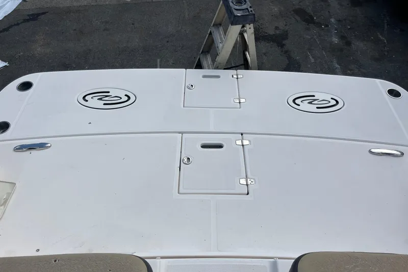 Slide: The Image of 2014 Regal 3200 Bowrider boat deck with storage compartments and logo. - 35