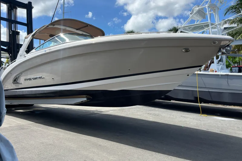 Slide: The Image of 2014 Regal 3200 Bowrider boat on a lift under a sunny sky. - 41