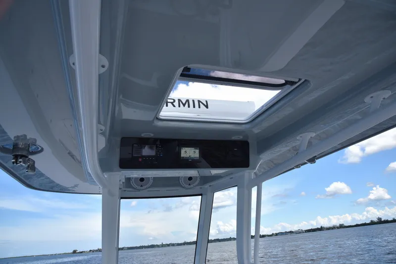 Slide: The Image of 2025 Jupiter 380 LS boat interior with Garmin navigation, overlooking calm waters and blue sky. - 5