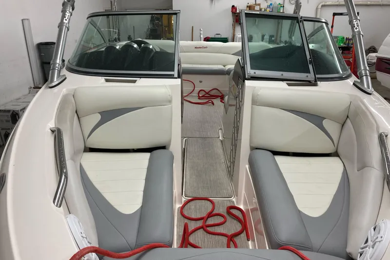 Slide: The Image of 2008 MasterCraft MariStar 215 boat interior with gray and white seating, red ropes, and windshield. - 14