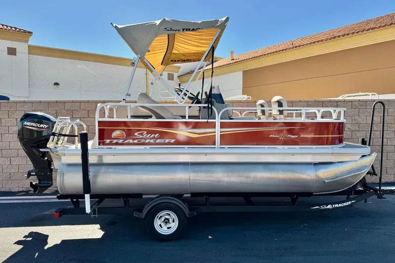 The Image of 2023 Sun Tracker Bass Buggy 16 XL pontoon boat with Mercury engine on trailer. - 0