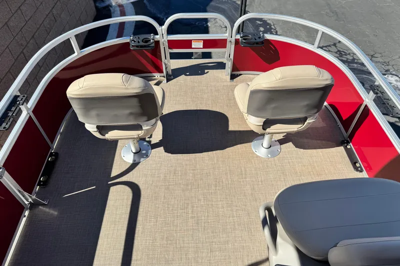 Slide: The Image of 2023 Sun Tracker Bass Buggy 16 XL pontoon boat interior with beige seats and red railing. - 10