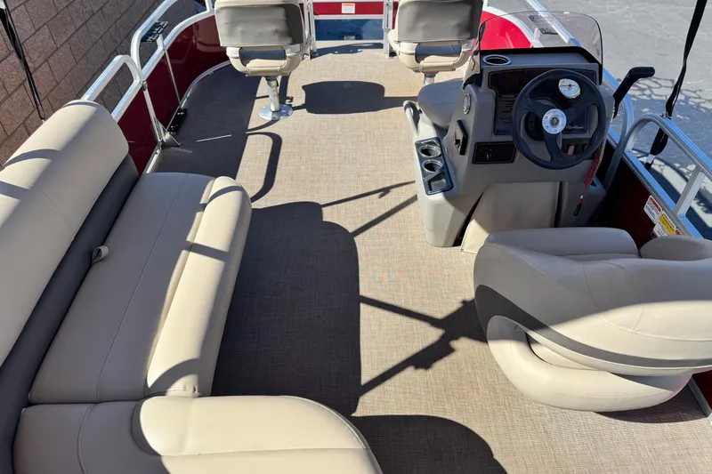 Slide: The Image of 2023 Sun Tracker Bass Buggy 16 XL interior with beige seating and steering console. - 16