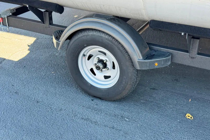 Slide: The Image of Trailer wheel of 2023 Sun Tracker Bass Buggy 16 XL on asphalt surface. - 22