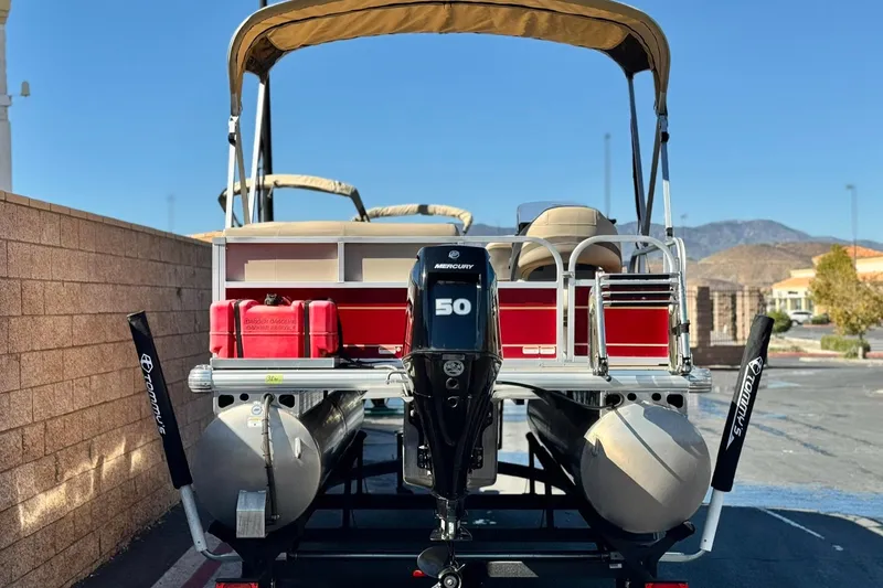 Slide: The Image of 2023 Sun Tracker Bass Buggy 16 XL pontoon boat with Mercury 50 engine, parked outdoors. - 5