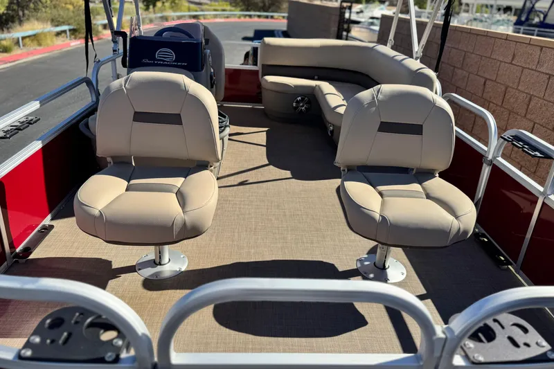 Slide: The Image of 2023 Sun Tracker Bass Buggy 16 XL interior with beige seating and red exterior. - 9