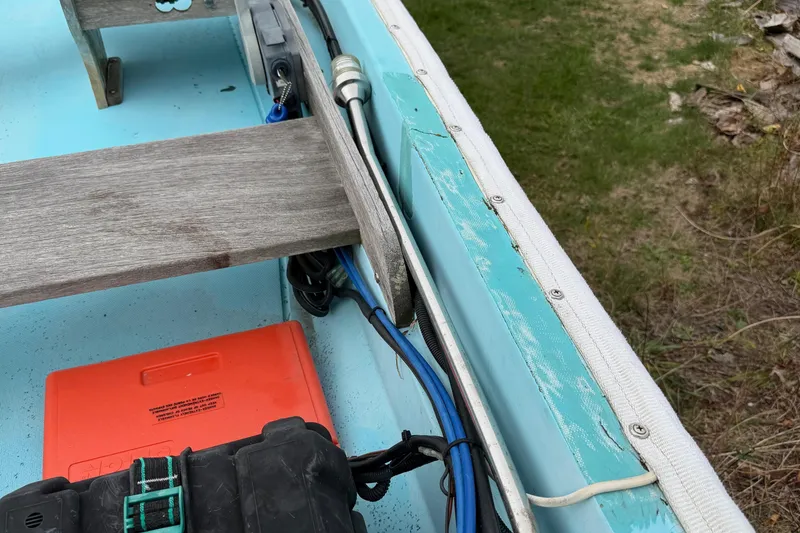 Slide: The Image of 1967 Boston Whaler 13 interior with wooden bench and visible wiring. - 10